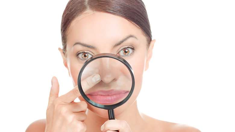 Woman with a magnifying glass on the center of her face 